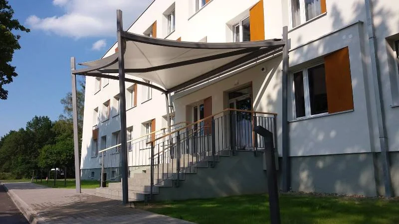 Membranowe zadaszenie wejścia do budynku na stalowych masztach