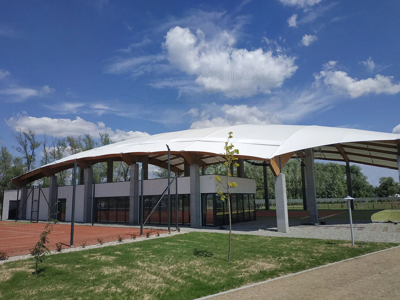 Łukowa hala membranowa na drewnianych dźwigarach zadaszająca obiekt sportowy