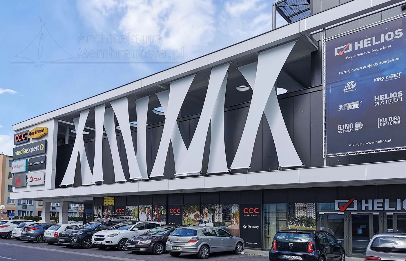 Membranowa fasada centrum handlowego z kinem Helios i szyldami sklepów, Legionowo